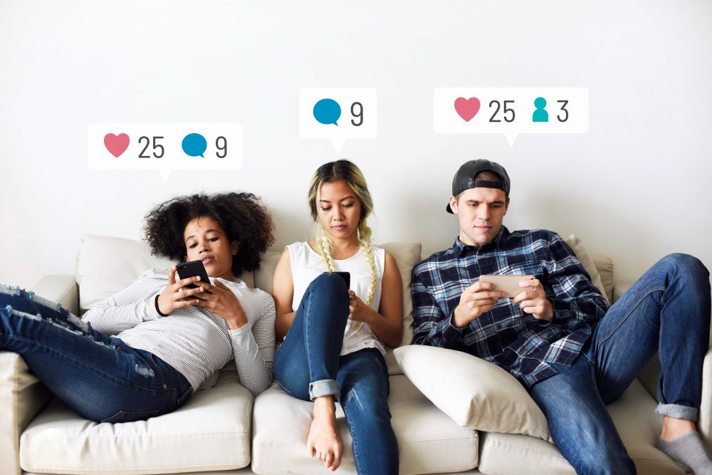 Three young people sit on a couch using their phones, with social media notification icons for likes, comments, and followers above their heads—capturing the vibrant energy of a 2026 influencer marketing campaign. Uploaded on aifreeforever.com