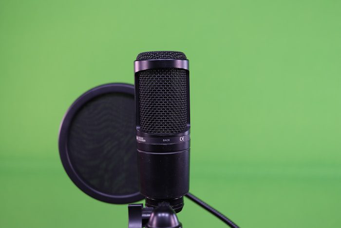 a microphone on a tripod with a green background