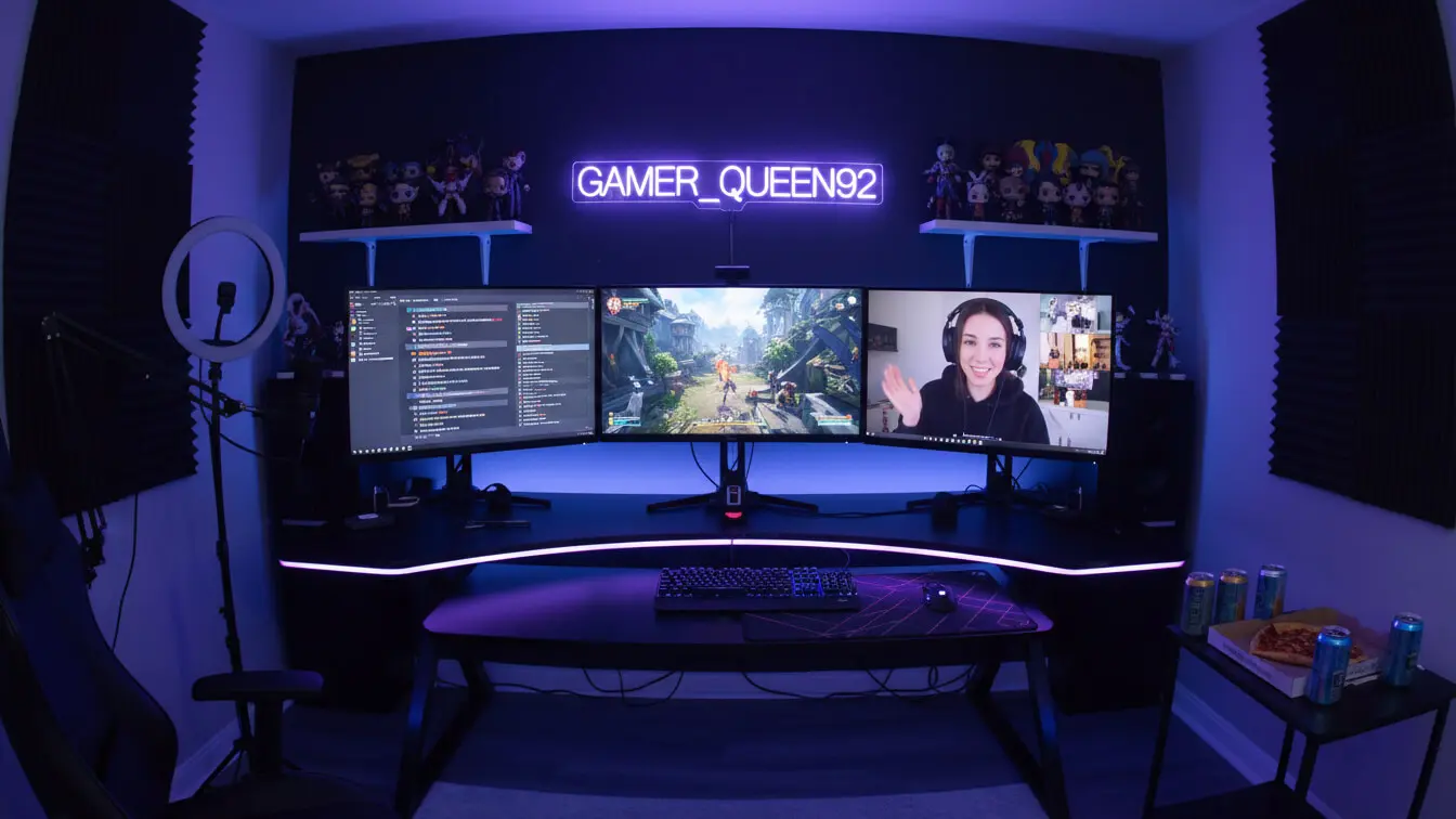 Dual-monitor gaming setup with neon GAMER_QUEEN92 sign, RGB lighting, and Short Clean Usernames on display; one screen shows a 2026 video call while the other features gameplay—complete with snacks and drinks. Uploaded on aifreeforever.com