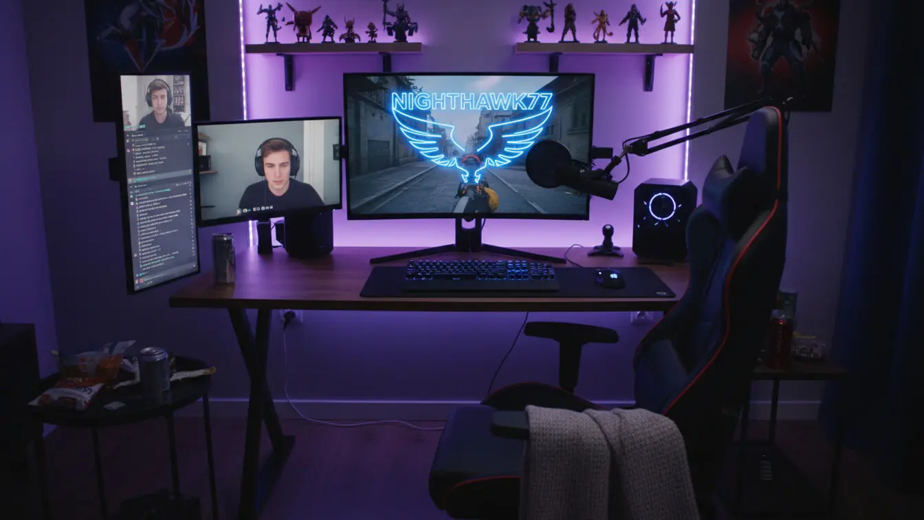 A gaming and streaming setup with two monitors, keyboard, mouse, microphone, gaming chair, and purple LED lighting—perfect for streamers in 2026—with collectibles on shelves above the desk and space for your Twitch username display. Uploaded on aifreeforever.com