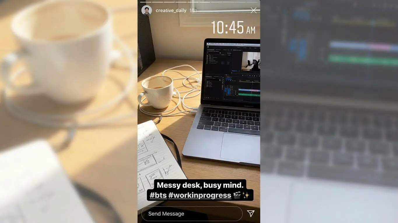 A laptop with video editing software, a notebook, coffee cup, and tangled cables are on a sunlit desk. Text overlay reads: Messy desk, busy mind. Try these Engagement Hacks for your Instagram Stories. #bts #workinprogress. Uploaded on aifreeforever.com