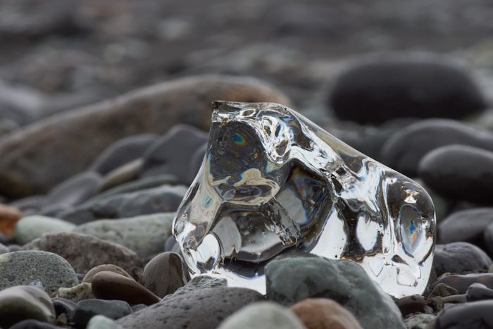 blue and white stone fragment on gray sand