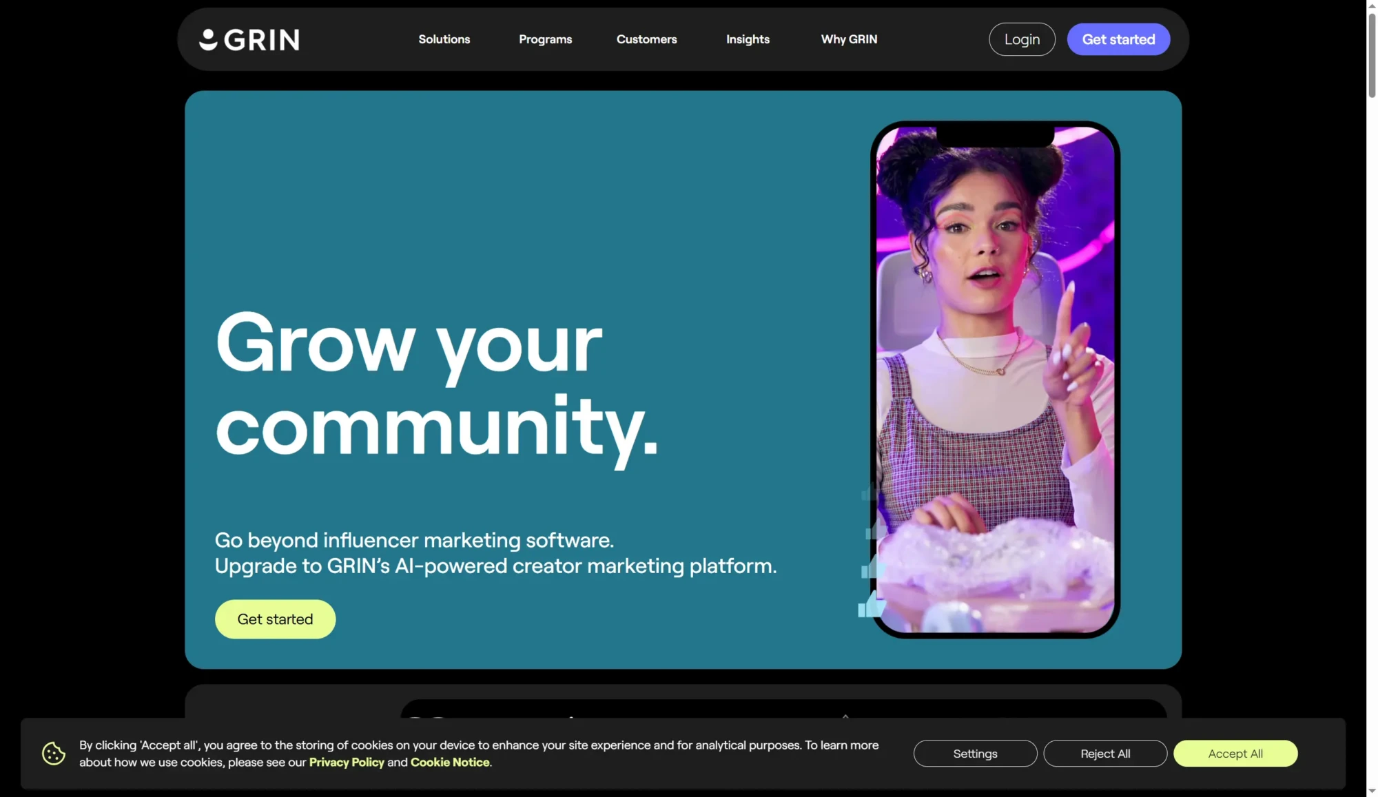 A woman gestures while speaking on a smartphone screen next to the text “Grow your community” on a website promoting an AI-powered creator marketing platform with powerful influencer marketing tools. Uploaded on aifreeforever.com