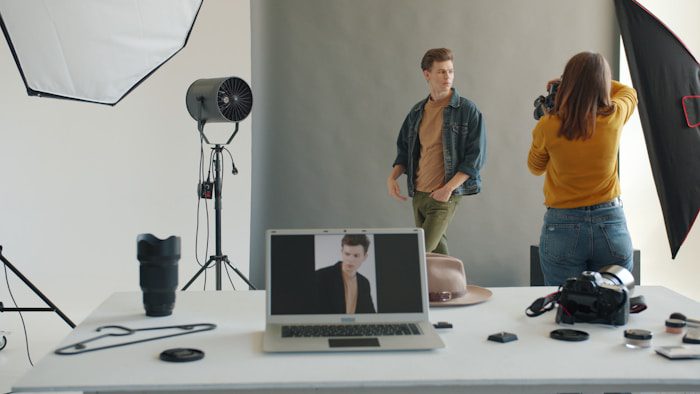Photographer taking picture of male mannequin in studio.