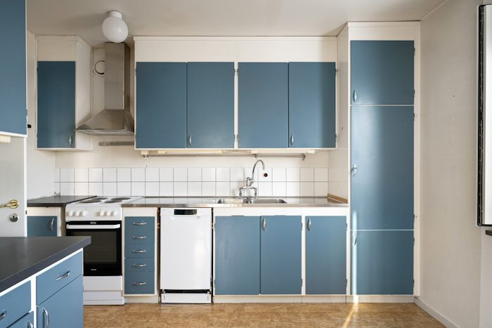 A kitchen with blue cabinets and white walls