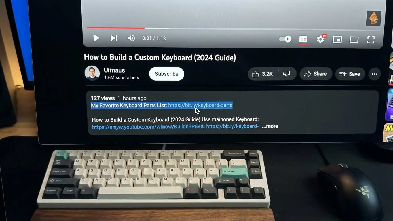 A mechanical keyboard with white and gray keys sits in front of a monitor displaying a YouTube video titled How to Build a Custom Keyboard [2024 Guide], perfect for crafting engaging YouTube descriptions or brushing up on SEO tips for 2026. Uploaded on aifreeforever.com